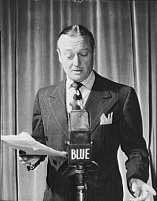 美国演员 Edmund Lowe 在广播麦克风(标有 NBC 蓝网)前站立,手持剧本,1942年
